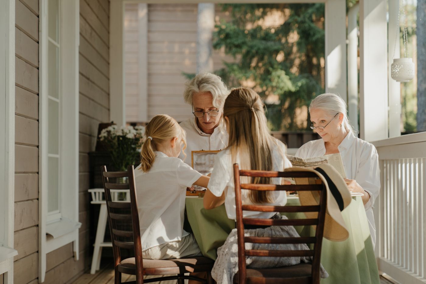 Three generations of a family together on a sunlit porch
